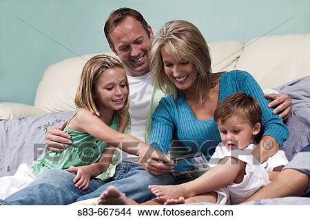 Family playing on floor in front of couch View Large Photo Image Picture - Family playing on floor in front of couch. Fotosearch