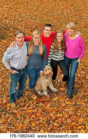 Family portrait, including goldendoodle poodle golden retriever mix in back yard of suburban home View Large Photo Image Stock Image - Family portrait, including goldendoodle poodle golden retriever mix in back yard of suburban home. Fotosearch