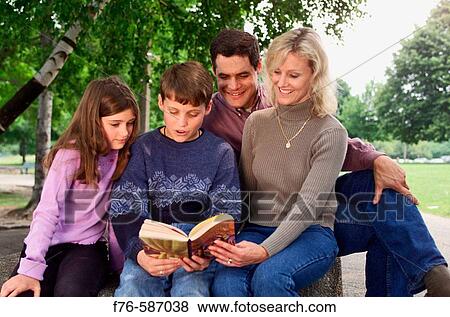 Family reading a book together. View Large Photo Image Stock Photo - Family reading a book together.. Fotosearch