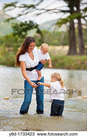Family river bathing fun - A woman with her 4 years old daughter and her 8 months old baby boy in the water View Large Photo Image Stock Image - Family river bathing fun - A woman with her 4 years old daughter and her 8 months old baby boy in the water. Fotosearch
