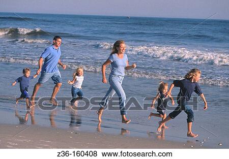 Family running on the beach View Large Photo Image Stock Photo - Family running on the beach. Fotosearch