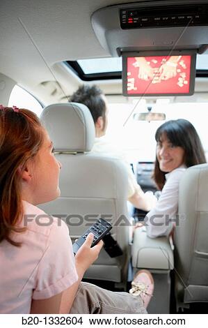 Family travelling, girl watching DVD in car View Large Photo Image Picture - Family travelling, girl watching DVD in car. Fotosearch