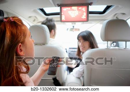 Family travelling, girl watching DVD in car View Large Photo Image Stock Image - Family travelling, girl watching DVD in car. Fotosearch