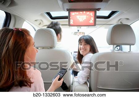 Family travelling, girl watching DVD in car View Large Photo Image Stock Image - Family travelling, girl watching DVD in car. Fotosearch