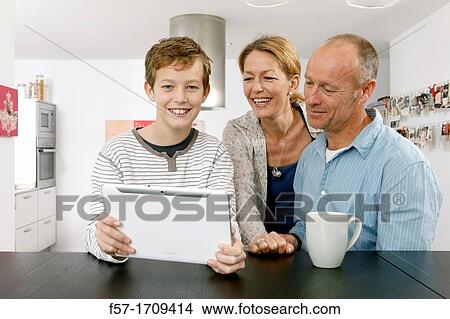 Family using tablet computer at home View Large Photo Image Picture - Family using tablet computer at home. Fotosearch