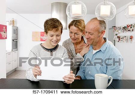 Family using tablet computer at home View Large Photo Image Stock Image - Family using tablet computer at home. Fotosearch