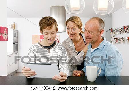 Stock Image - Family using tablet computer at home. Fotosearch