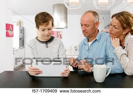 Family using tablet computer at home View Large Photo Image Stock Photo - Family using tablet computer at home. Fotosearch