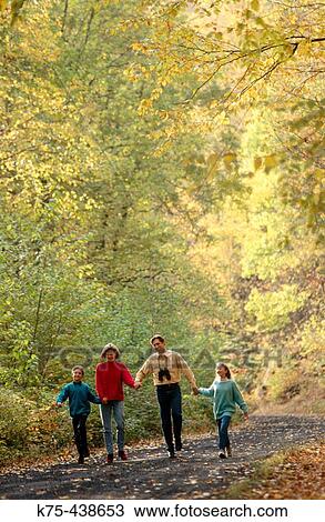 Stock Image - Family walking together down country road. Fotosearch