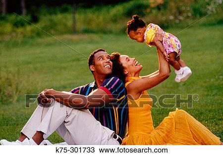 family with their infant sitting on the lawn View Large Photo Image Stock Image - family with their infant sitting on the lawn. Fotosearch