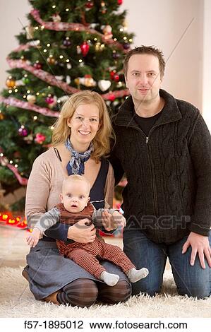 Family with their six month year old baby at Christmas View Large Photo Image Stock Image - Family with their six month year old baby at Christmas. Fotosearch