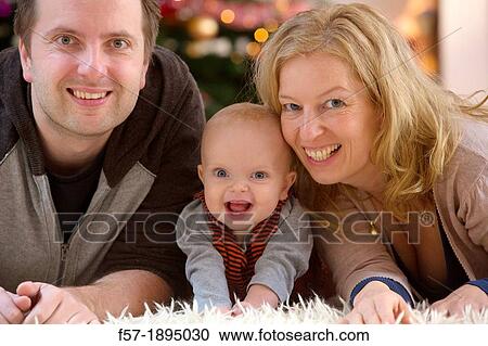 Family with their six month year old baby at Christmas View Large Photo Image Stock Image - Family with their six month year old baby at Christmas. Fotosearch