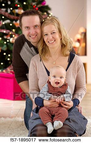 Family with their six month year old baby at Christmas View Large Photo Image Stock Photo - Family with their six month year old baby at Christmas. Fotosearch