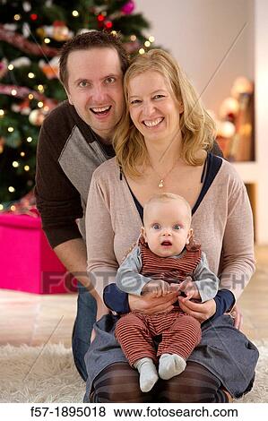 Family with their six month year old baby at Christmas View Large Photo Image Stock Photo - Family with their six month year old baby at Christmas. Fotosearch