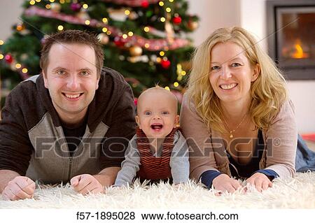 Family with their six month year old baby at Christmas View Large Photo Image Stock Photo - Family with their six month year old baby at Christmas. Fotosearch