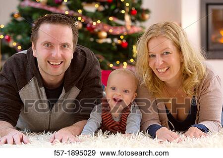 Family with their six month year old baby at Christmas View Large Photo Image Stock Photo - Family with their six month year old baby at Christmas. Fotosearch