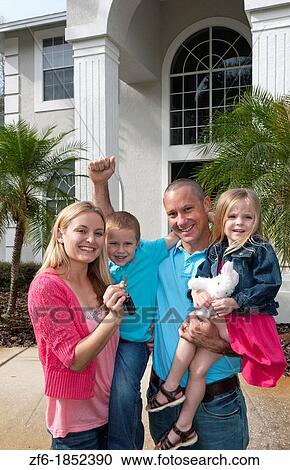 Family with two small chidren moving into new expensive home with keys from real estate the american dream View Large Photo Image Stock Image - Family with two small chidren moving into new expensive home with keys from real estate the american dream. Fotosearch