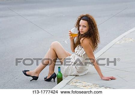 Fanciful girl at the edge of a roadway with a bottle View Large Photo Image Picture - Fanciful girl at the edge of a roadway with a bottle. Fotosearch