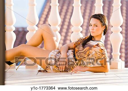 Picture - Fanciful girl is lying on a balcony. Fotosearch