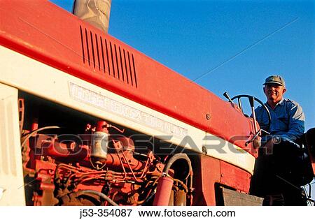 Stock Photo - Farmer on tractor. Jefferson County, Nebraska. USA.. Fotosearch
