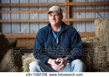 Farmer sitting on haystacks inside barn, Salisbury MD View Large Photo Image Stock Photo - Farmer sitting on haystacks inside barn, Salisbury MD. Fotosearch