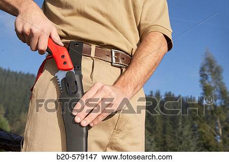 Stock Photo - Farmer with pruning handsaw. Fotosearch