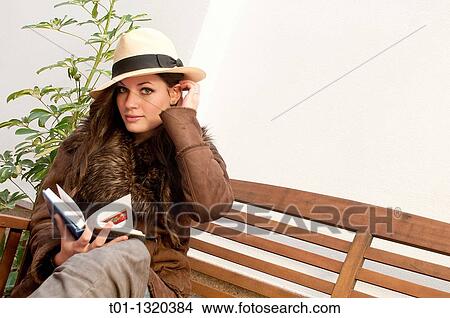 Fashionable girl with Panama hat reading a book outdoors View Large Photo Image Picture - Fashionable girl with Panama hat reading a book outdoors. Fotosearch