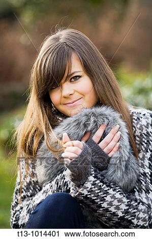 Stock Image - Fashionable young woman is warm with a fur in her hands. Fotosearch
