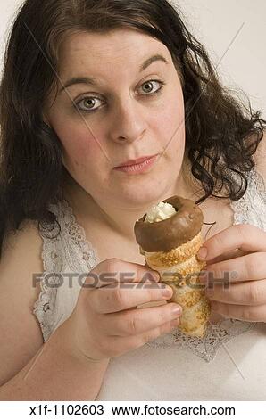 Fat overweight young woman guiltily eating a chocolate cream horn View Large Photo Image Stock Image - Fat overweight young woman guiltily eating a chocolate cream horn. Fotosearch