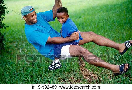 fater and son on a rope swing View Large Photo Image Stock Photo - fater and son on a rope swing. Fotosearch