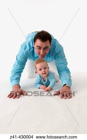Picture - Father and baby crawling together. Fotosearch