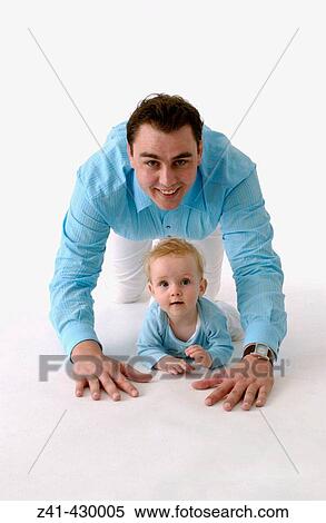 Stock Photography - Father and baby crawling together. Fotosearch
