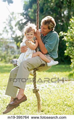 Picture - father and daughter on a rope swing. Fotosearch