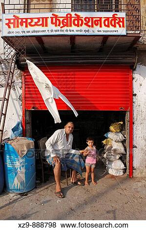 Stock Photo - Father and his little daughter at his little? shop? in Mumbai. Fotosearch