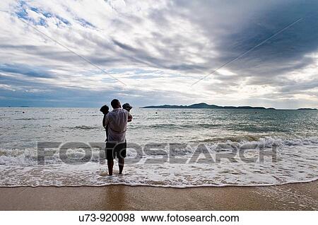 Father and his twins enjoy the sunset on a tropical beach. View Large Photo Image Stock Photo - Father and his twins enjoy the sunset on a tropical beach.. Fotosearch