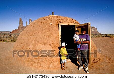 Father and his two children. Traditional Hogan (navajo mud hut) by the three sisters peaks. Monument valley, Navajo reservation. Utah. United states (USA). View Large Photo Image Stock Photograph - Father and his two children. Traditional Hogan (navajo mud hut) by the three sisters peaks. Monument valley, Navajo reservation. Utah. United states (USA).. Fotosearch