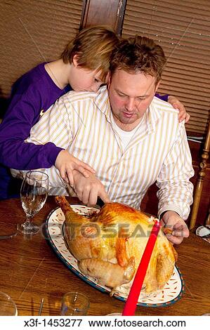 Father and son carving the Christmas turkey St Paul Minnesota USA View Large Photo Image Stock Photo - Father and son carving the Christmas turkey St Paul Minnesota USA. Fotosearch