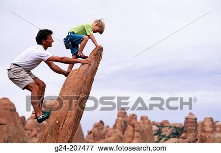 Father and son climbing a sandstone slab. Utah. USA View Large Photo Image Stock Photo - Father and son climbing a sandstone slab. Utah. USA. Fotosearch