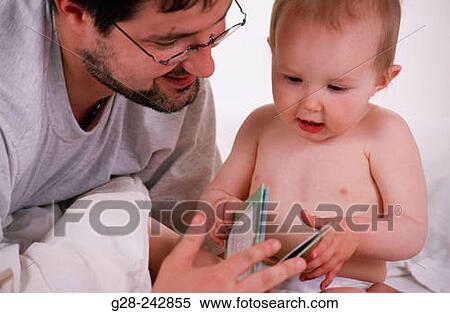 Stock Photography - Father and son leafing through the pages of a book.. Fotosearch