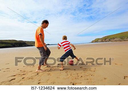 father and son playing football on beach, Sutherland, Scotland View Large Photo Image Picture - father and son playing football on beach, Sutherland, Scotland. Fotosearch