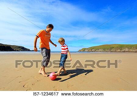father and son playing football on beach, Sutherland, Scotland View Large Photo Image Stock Photo - father and son playing football on beach, Sutherland, Scotland. Fotosearch