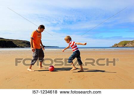 father and son playing football on beach, Sutherland, Scotland View Large Photo Image Stock Photo - father and son playing football on beach, Sutherland, Scotland. Fotosearch