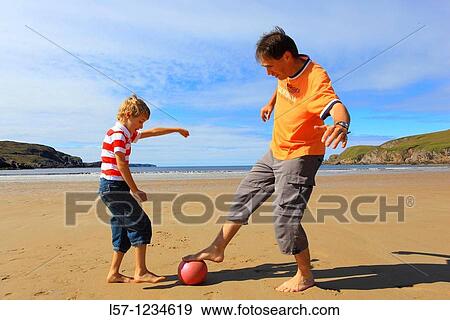 father and son playing football on beach, Sutherland, Scotland View Large Photo Image Stock Photo - father and son playing football on beach, Sutherland, Scotland. Fotosearch
