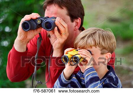 Father and son using binoculars to watch birds, birdwatching. View Large Photo Image Stock Image - Father and son using binoculars to watch birds, birdwatching.. Fotosearch