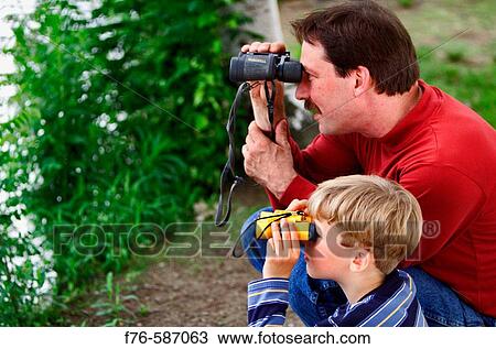 Father and son using binoculars to watch birds, birdwatching. View Large Photo Image Stock Image - Father and son using binoculars to watch birds, birdwatching.. Fotosearch