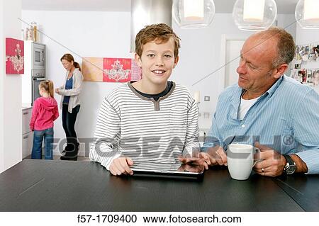 Father and son using tablet computer at home View Large Photo Image Stock Image - Father and son using tablet computer at home. Fotosearch