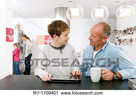 Father and son using tablet computer at home View Large Photo Image Stock Image - Father and son using tablet computer at home. Fotosearch