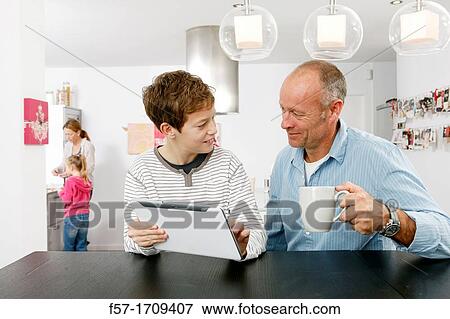 Father and son using tablet computer at home View Large Photo Image Stock Photo - Father and son using tablet computer at home. Fotosearch