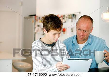 Father and son using tablet computer View Large Photo Image Stock Image - Father and son using tablet computer. Fotosearch