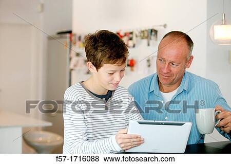 Father and son using tablet computer View Large Photo Image Stock Photo - Father and son using tablet computer. Fotosearch